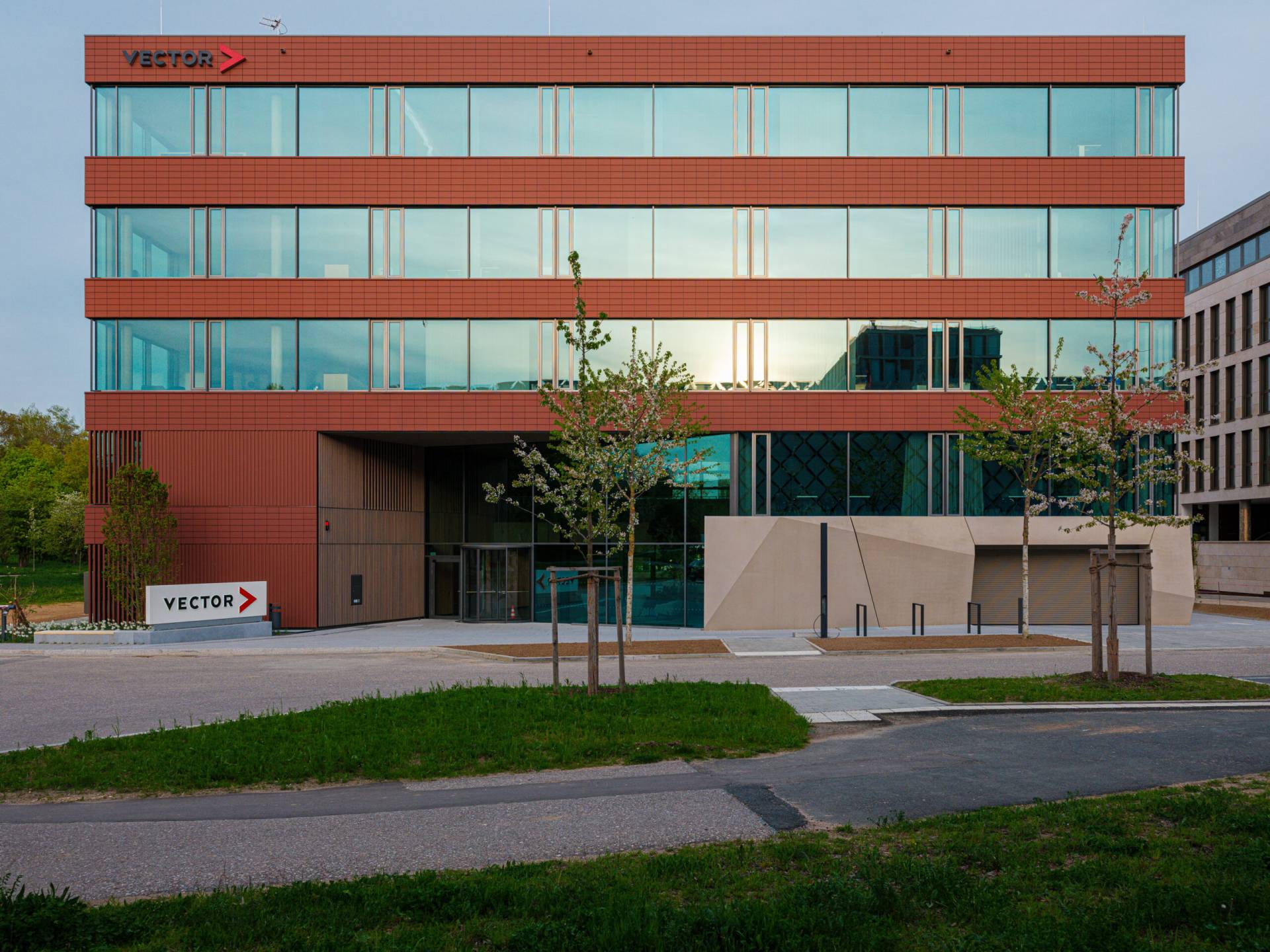 Frontalansicht des neuen Vector-Bürogebäudes in Regensburg mit Spiegelung des Sonnenuntergangs in der TechBase Regensburg