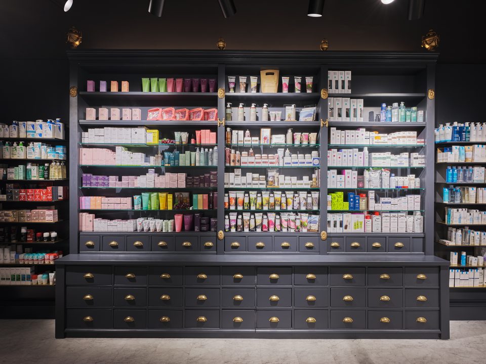 Frontale Ansicht der Apothekerschrankwand, Vitrinen über einem Raster aus Schubladen mit Messinggriffen