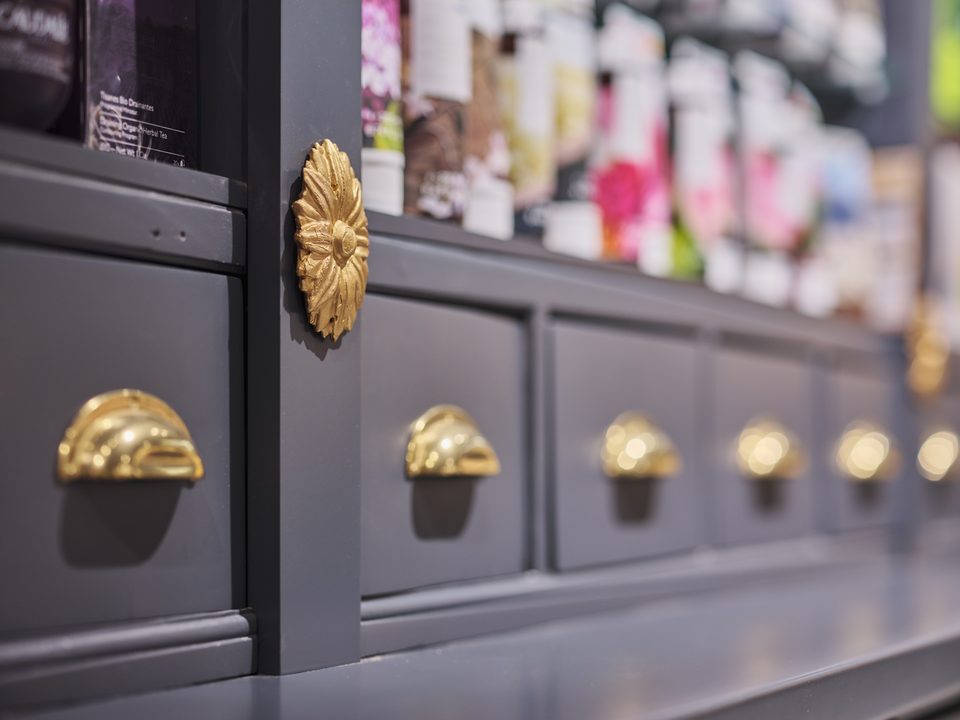 Nahaufnahme der goldenen Muschelgriffe und der Messingrosette auf mattschwarzem Holz