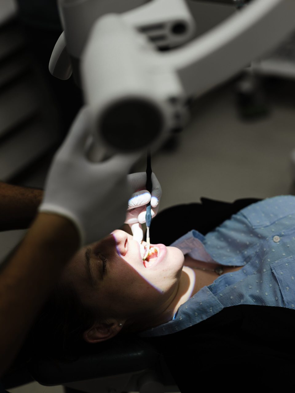 Blick über die Schulter der Behandlerin auf den Patienten im Stuhl während der Kontrolle