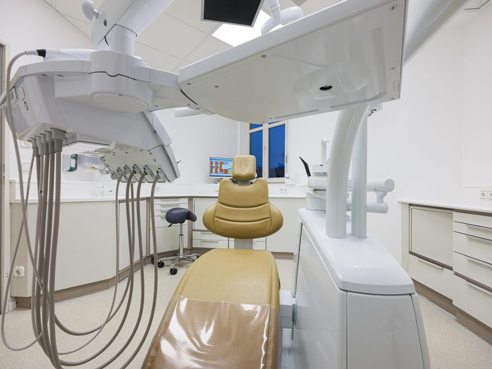 Behandlungszimmer aus niedriger Perspektive, im Vordergrund der Geräteträger mit den Schläuchen