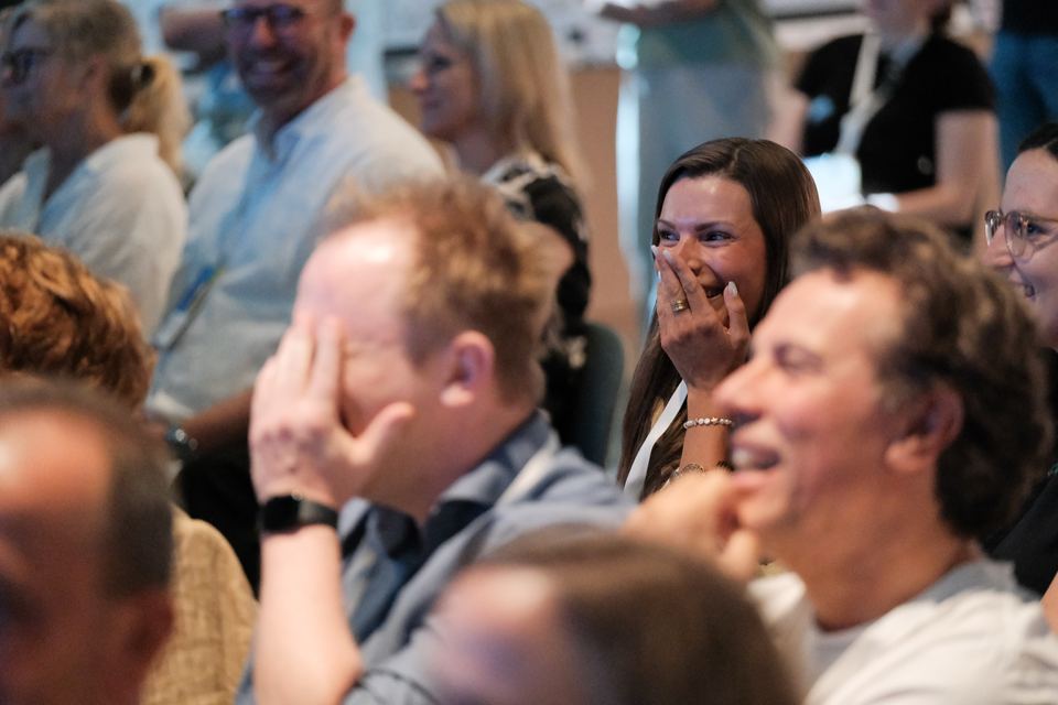 Teilnehmende im Publikum lachen herzlich