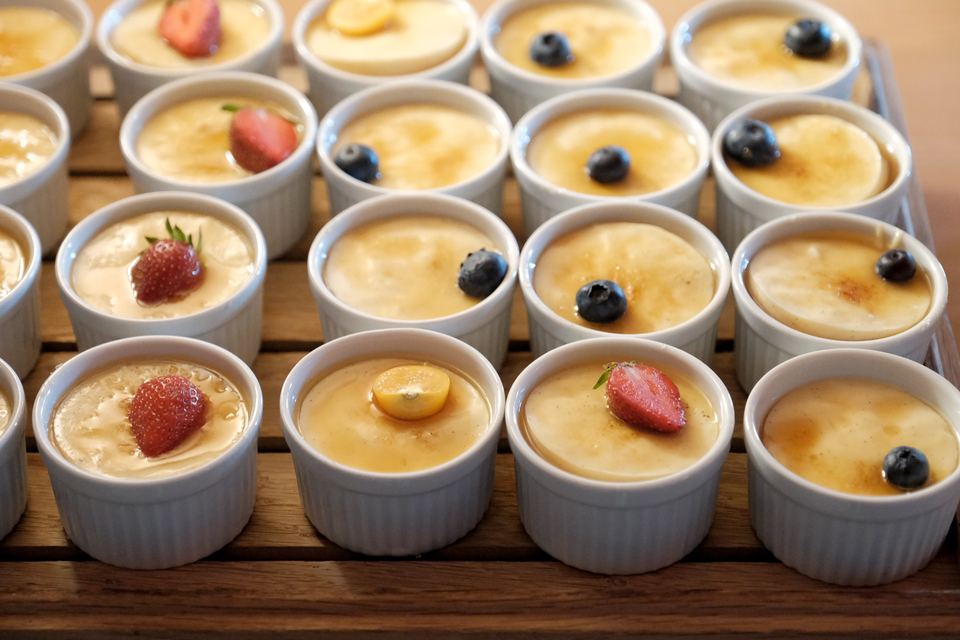 Reihen von Crème brûlée mit Erdbeeren und Heidelbeeren am Buffet