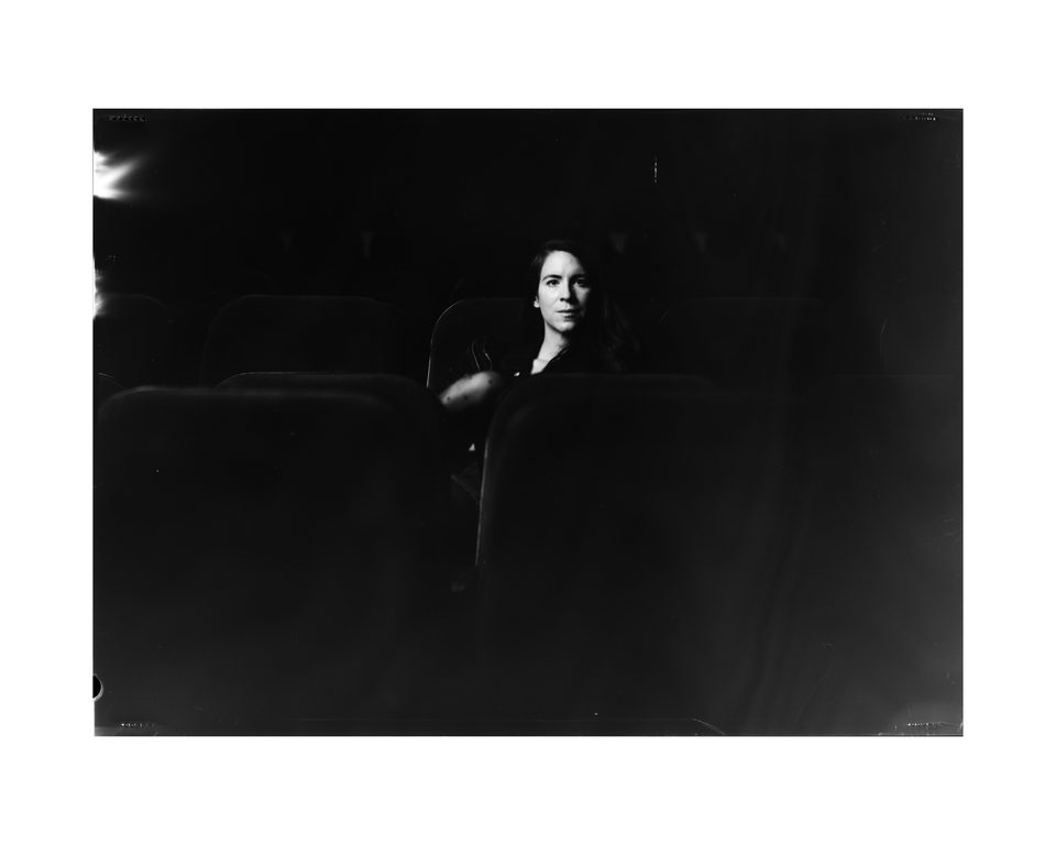 Portrait der Schauspielerin und Regisseurin Flora im Zuschauerraum eines Regensburger Theaters mit einer Großbildkamera auf Negativfilm