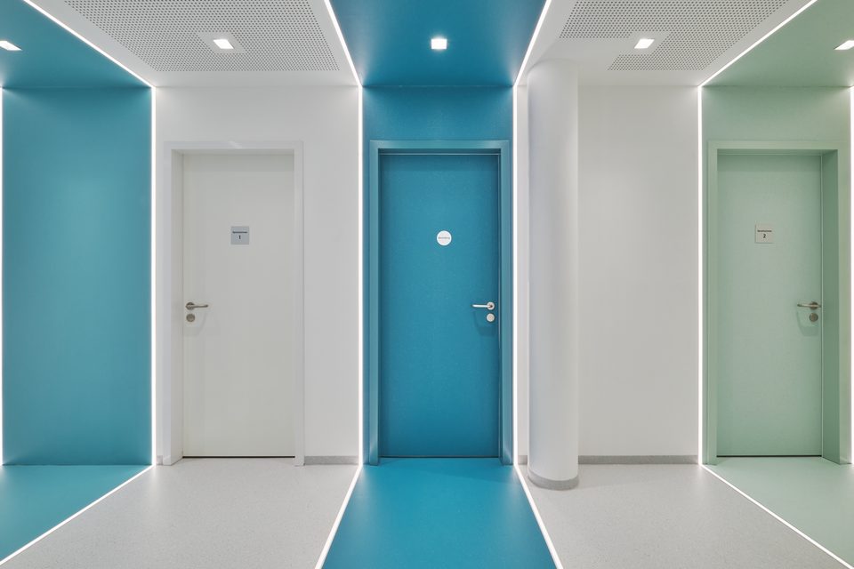 Flur mit farbig gefassten Türnischen, Türkis in der Mitte und Mintgrün rechts, die Farbe läuft jeweils über Boden, Wand und Decke durch