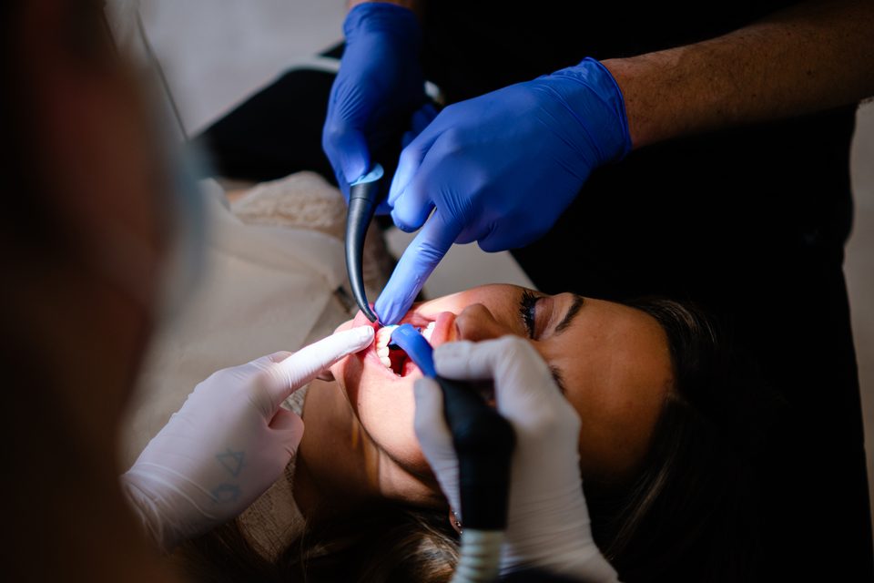 Nahaufnahme der Behandlung: Team mit Instrumenten und Scanner an der Patientin