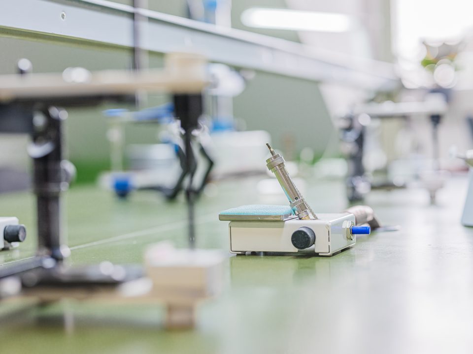 Nahaufnahme eines Bunsenbrenners auf der apfelgrünen Laborfläche