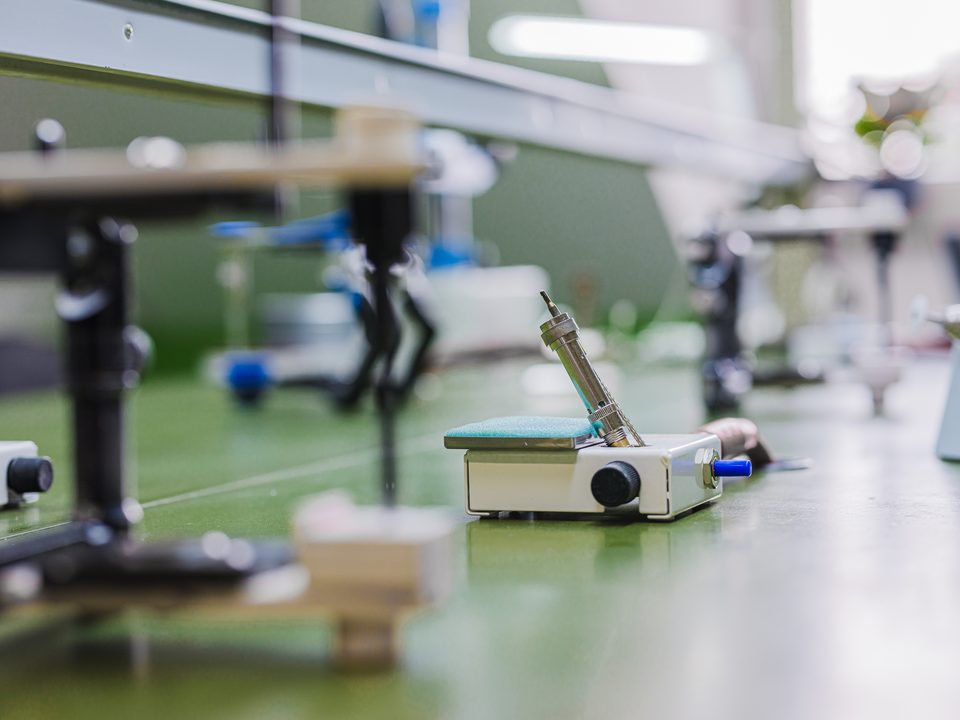 Nahaufnahme eines Bunsenbrenners auf der apfelgrünen Laborfläche