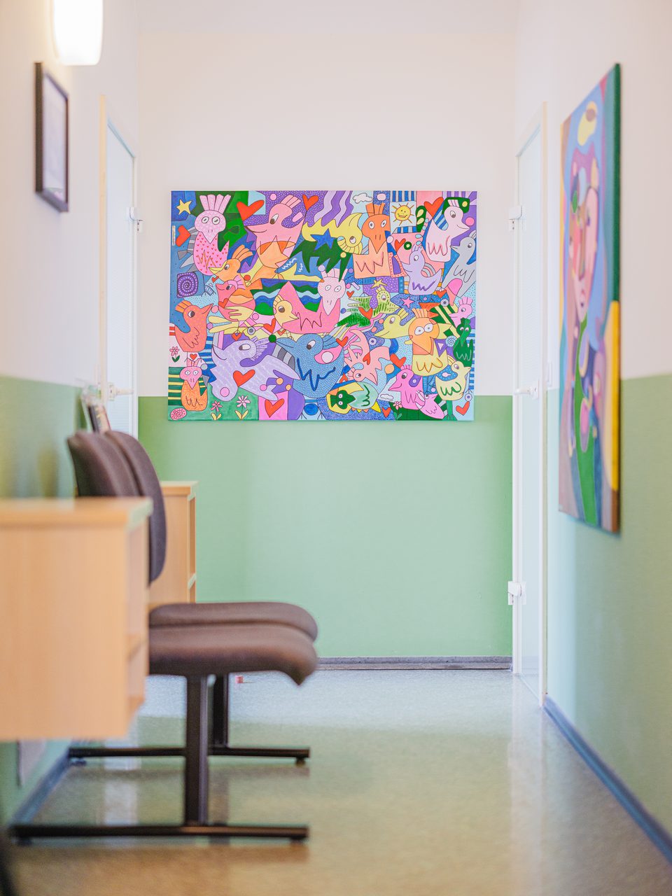 Flur mit Sitzecke und buntem abstraktem Gemälde an der apfelgrünen Wand