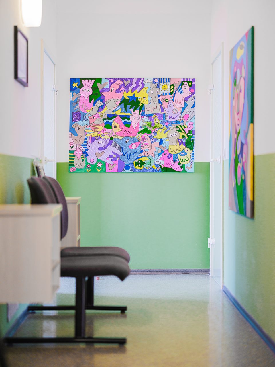 Flur mit Sitzecke und buntem abstraktem Gemälde an der apfelgrünen Wand