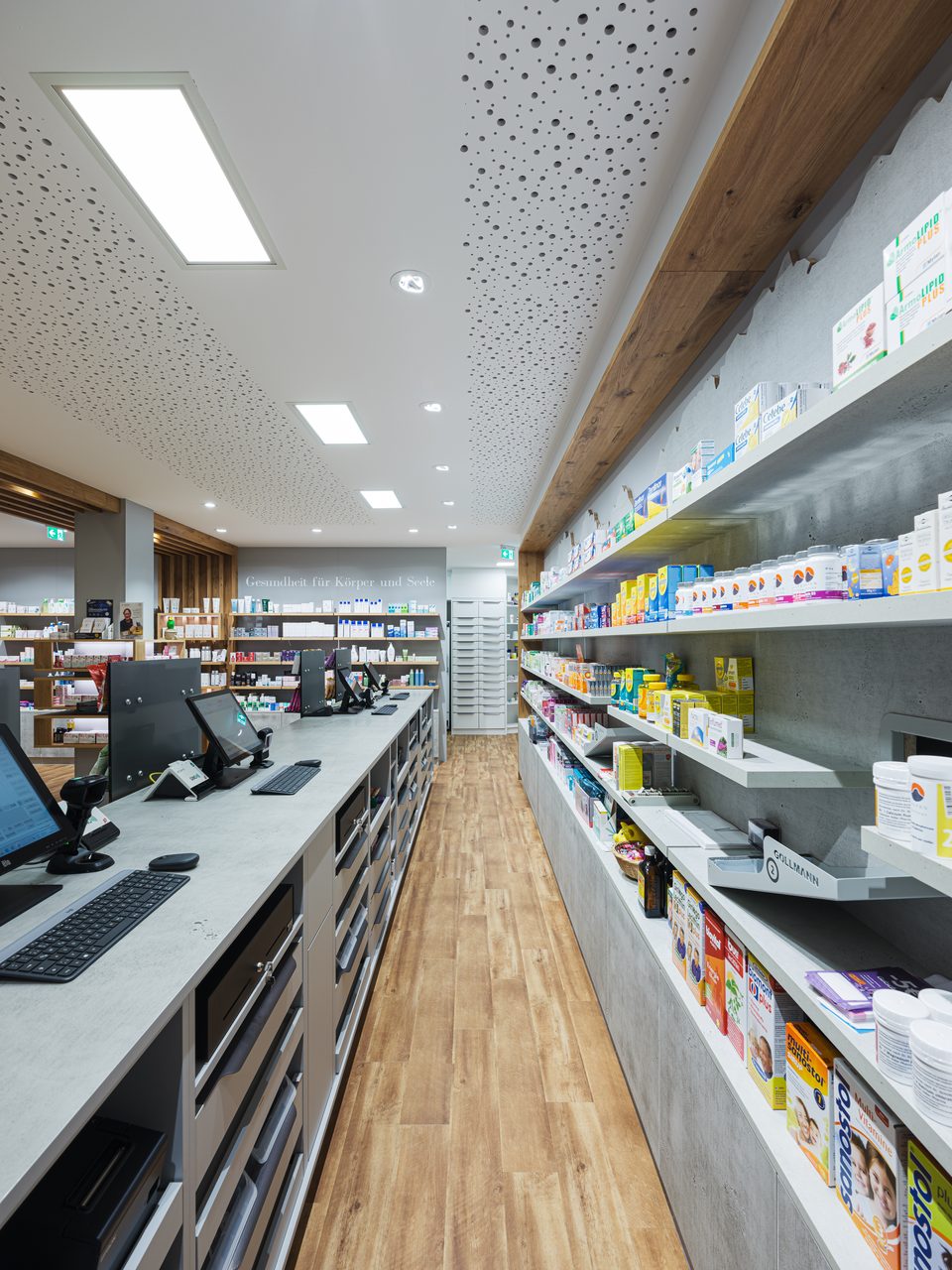 Rückseite der Offizin der Salven-Apotheke Söll mit Arbeitsplätzen hinter der Theke