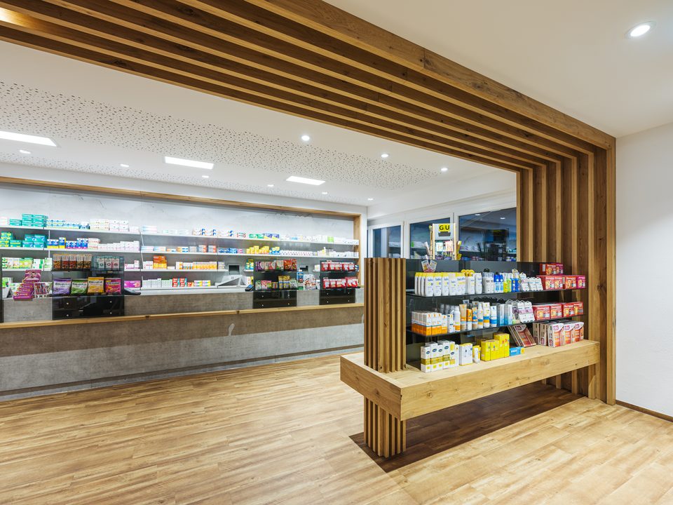 Verkaufsraum der Salven-Apotheke mit Holzapplikationen und Offizin