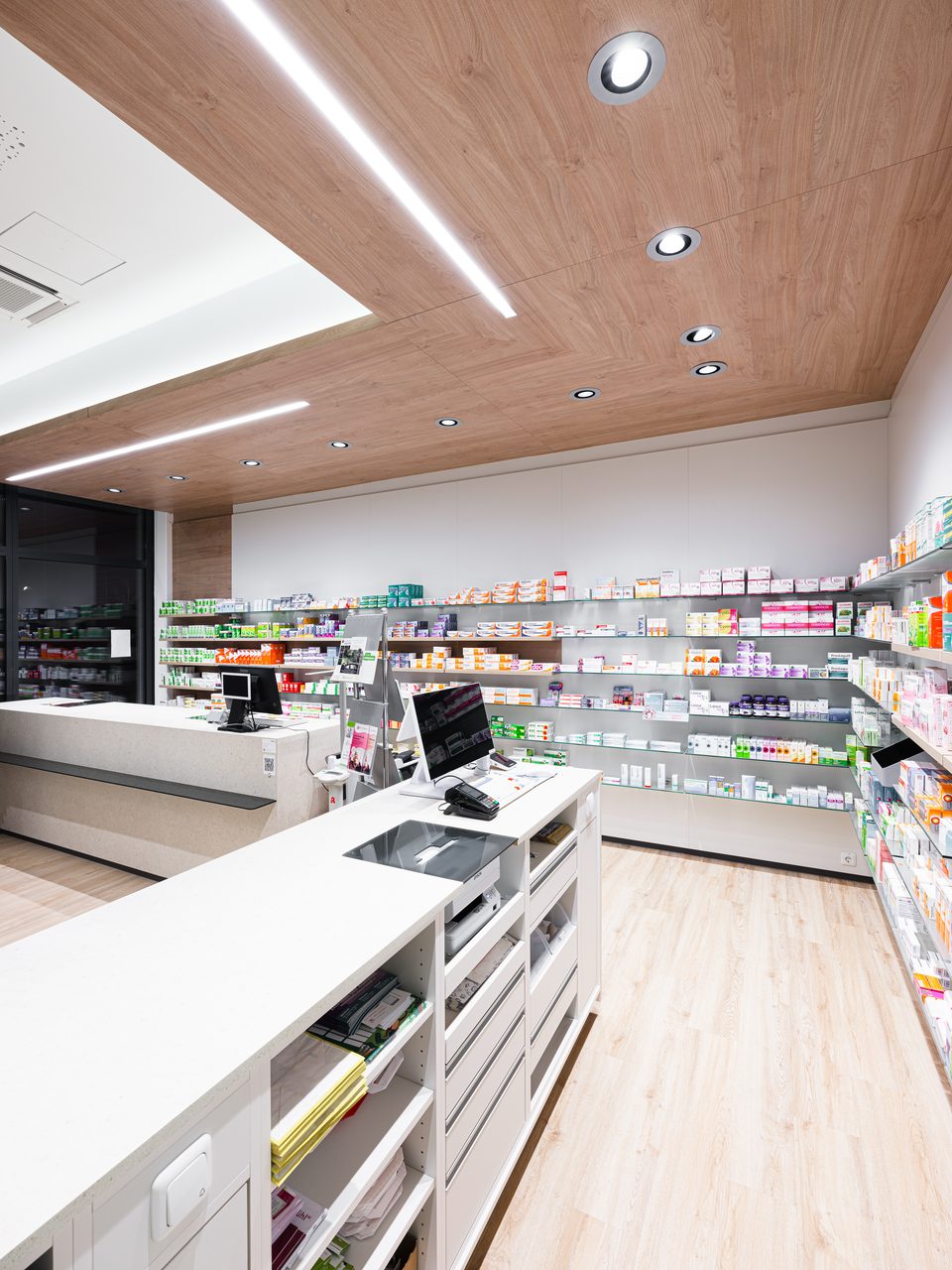 Hochformat entlang der Regale mit Detail der Holzdecke und LED-Spots