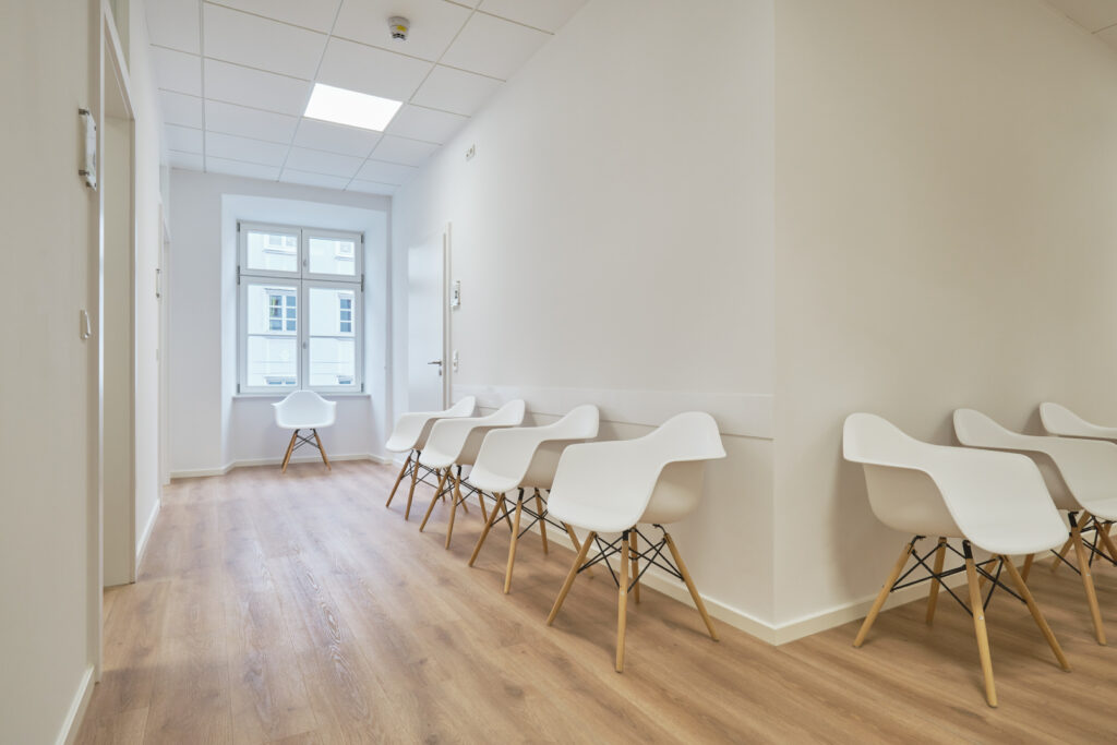 Flur mit einigen modernen Stühlen der Gemeinschaftspraxis Vilshofen, Innenarchitektur / Interior Design von Planquelle