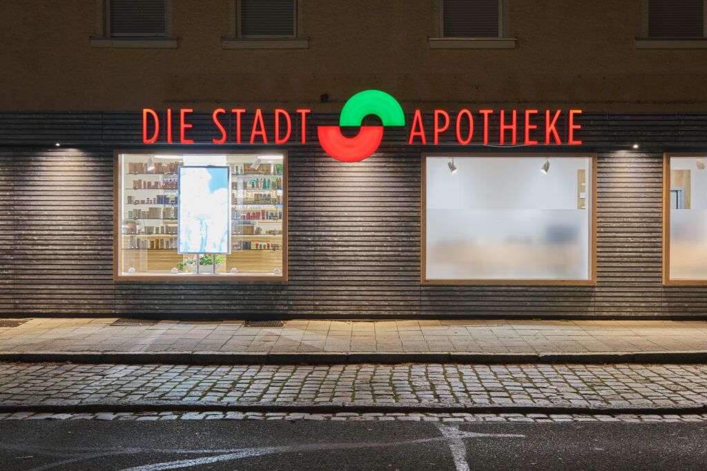 Stadtapotheke Grafenwöhr, Innenarchitektur / Interior Design von Planquelle, Nachtansicht der Außenfassade