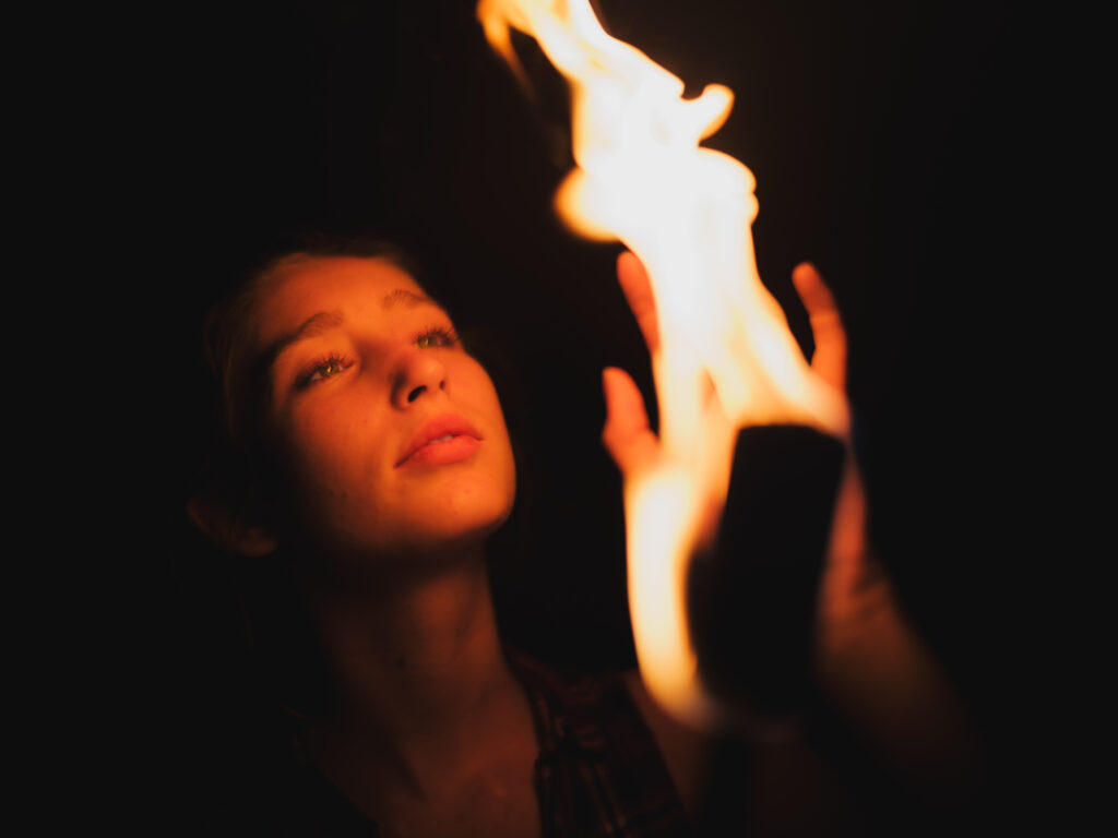 Portraitfotos einer jungen Frau beim Feuerjuggling im Feuerschein auf der Burgruine Brennberg bei Regensburg