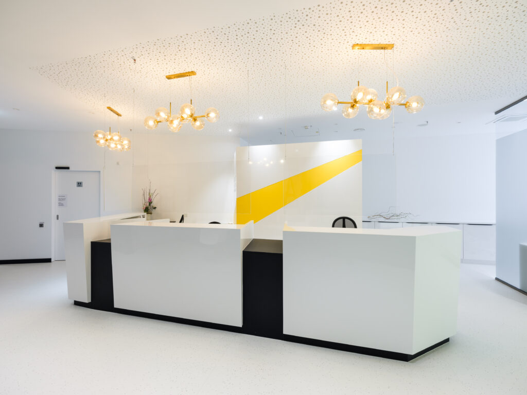 Augenärzte und Laserzentrum im DEZ in Regensburg, Innenarchitektur / Interior Design von Planquelle, Empfanstresen in geradem und kantigem Design mit gelben Akzenten.