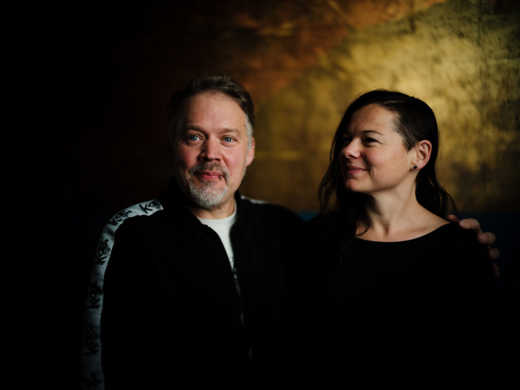 Paar professionell fotografiert in der Vinyl Bar Regensburg mit sehr schmalem Schärfebereich und goldenem Hintergrund