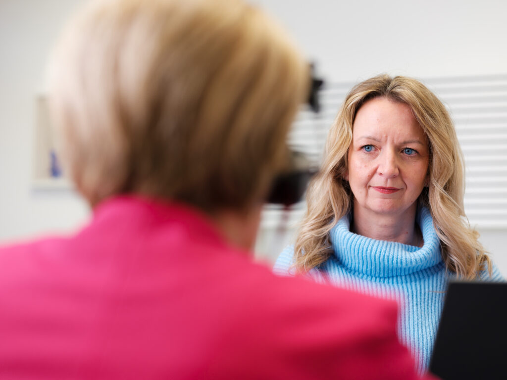 Portrait einer Hörgeräteakustikerin im Gespräch mit einer Kundin