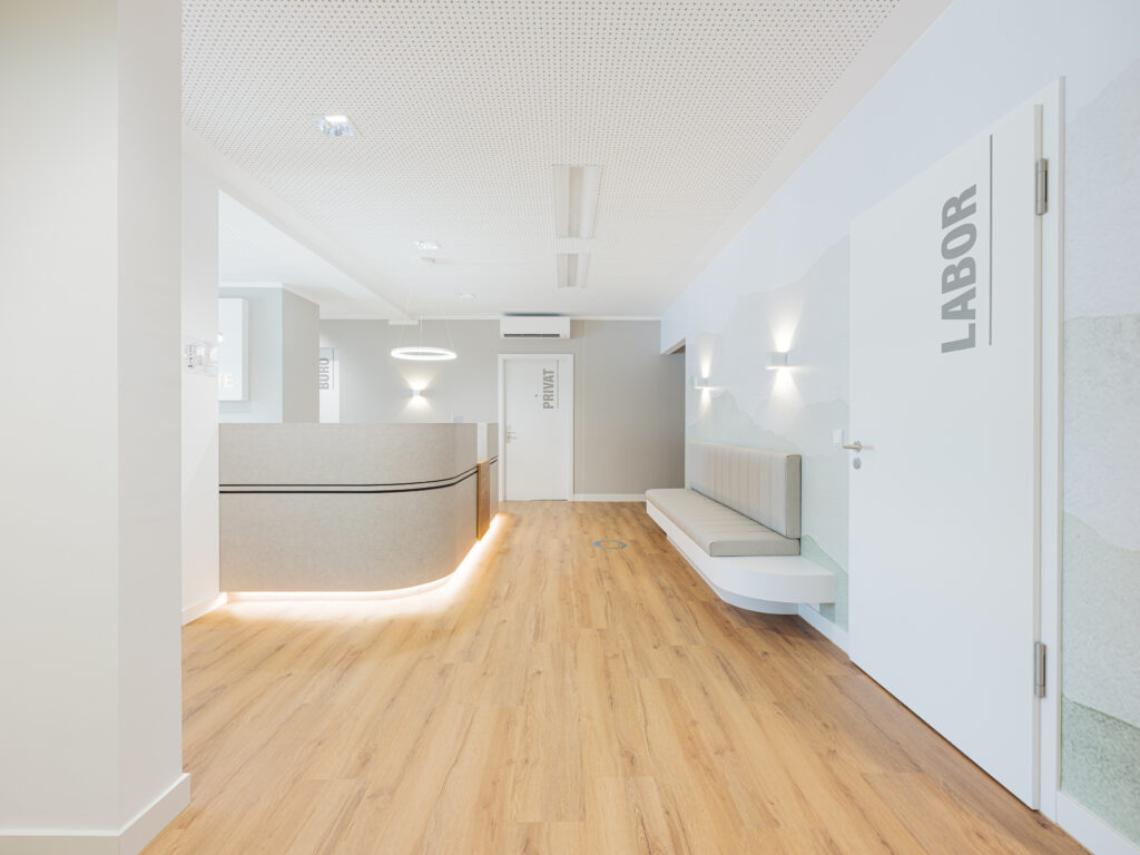 Blick entlang des hellen Flurs mit schwebend wirkender Theke, professionell fotografiert vom Architekturfotograf Alexander Gerner.