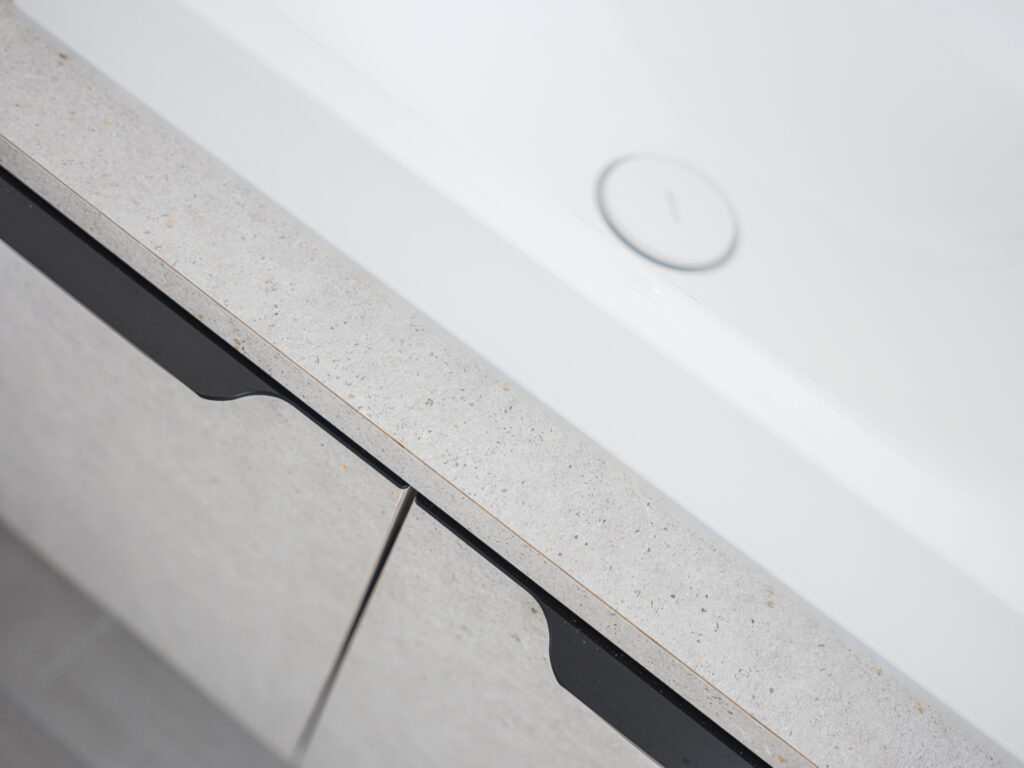 Minimalistisches Waschbecken mit Natursteinplatte in der Arztpraxis Kögel & Schmiedecke, festgehalten von Architekturfotograf Alexander Gerner.