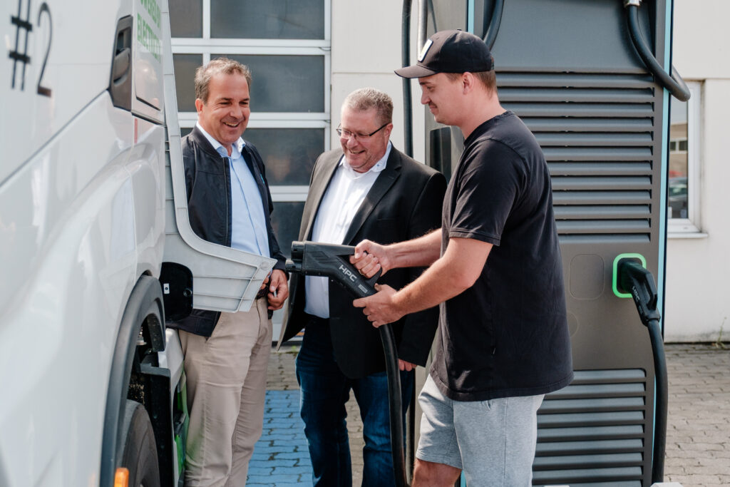 Besprechung neben der Ladebuchse eines Elektro-LKWs – aufgenommen von Businessfotograf Alexander Gerner in Regensburg