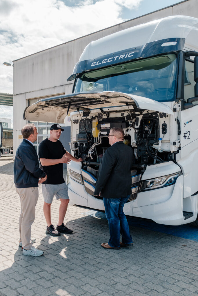 Technisches Briefing am geöffneten Motorraum eines Elektro-LKWs – dokumentiert von Businessfotograf Alexander Gerner
