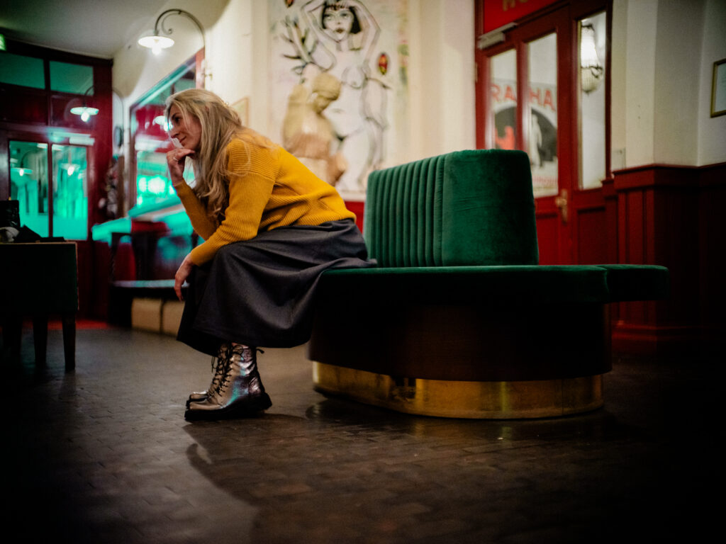 Portraitfotograf Alexander Gerner: Frau sitzt auf historischem Rundsofa im Hotel Orphée Regensburg, authentisches Portrait.