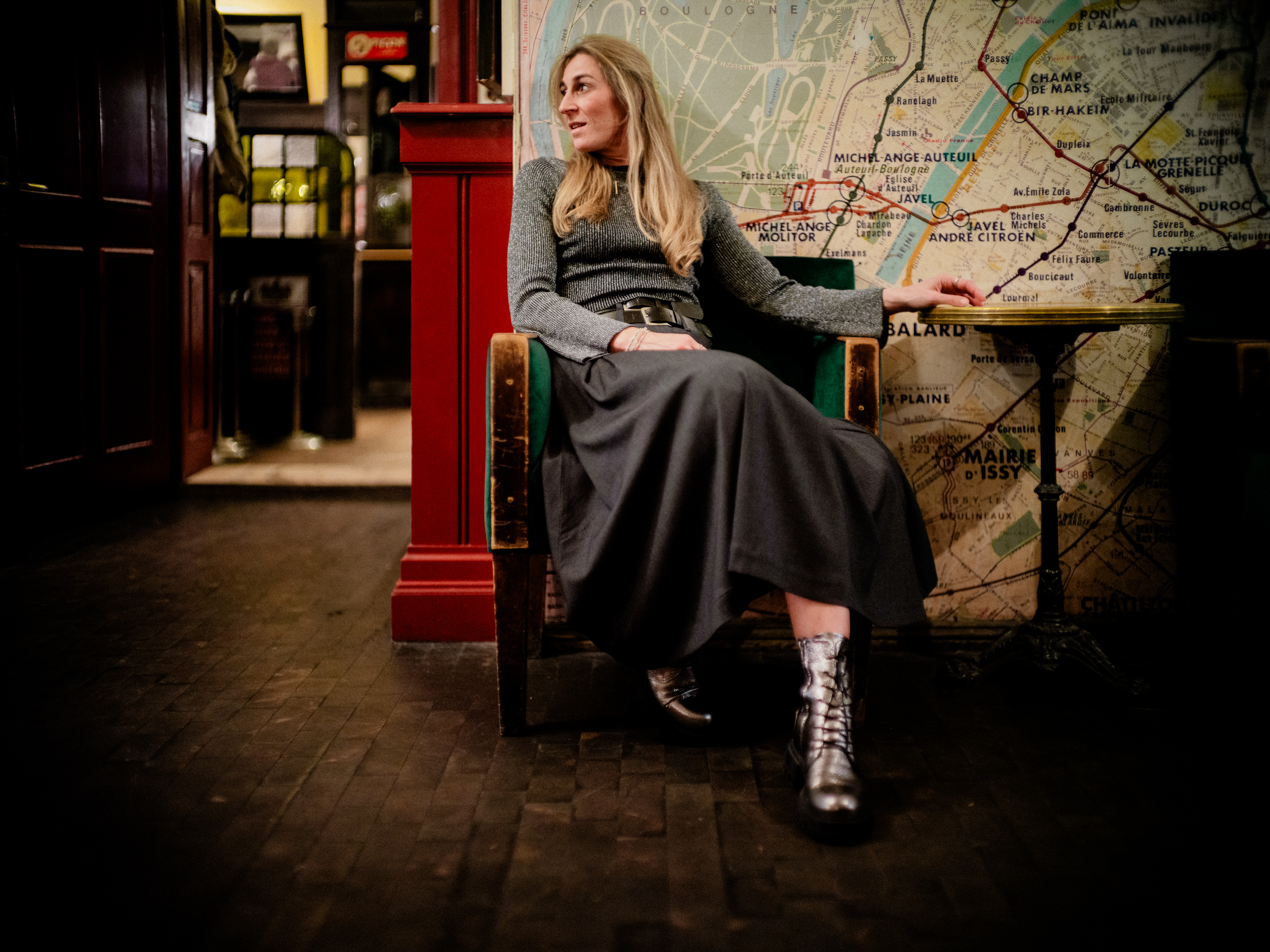 Portraitfotografie von Alexander Gerner: Frau sitzt elegant auf einem grünen Sessel im Hotel Orphée Regensburg, stilvolles Porträt im historischen Ambiente.
