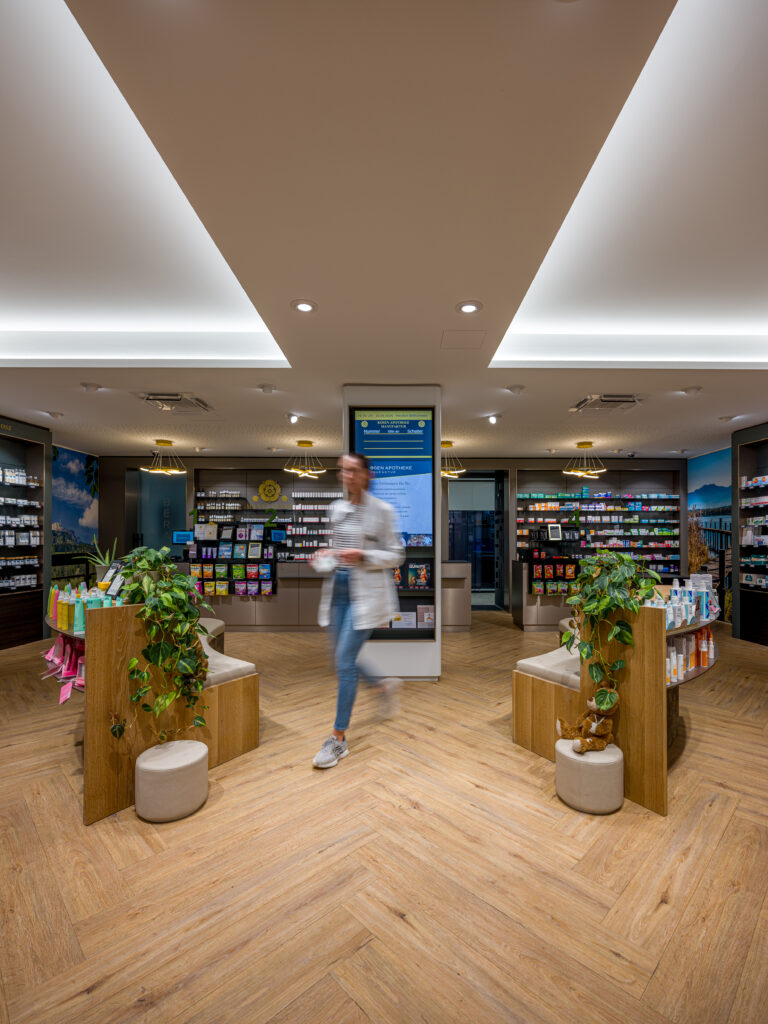 Innenaufnahme der Rosenapotheke mit Apothekenmitarbeiterin – Architekturfotografie von Alexander Gerner