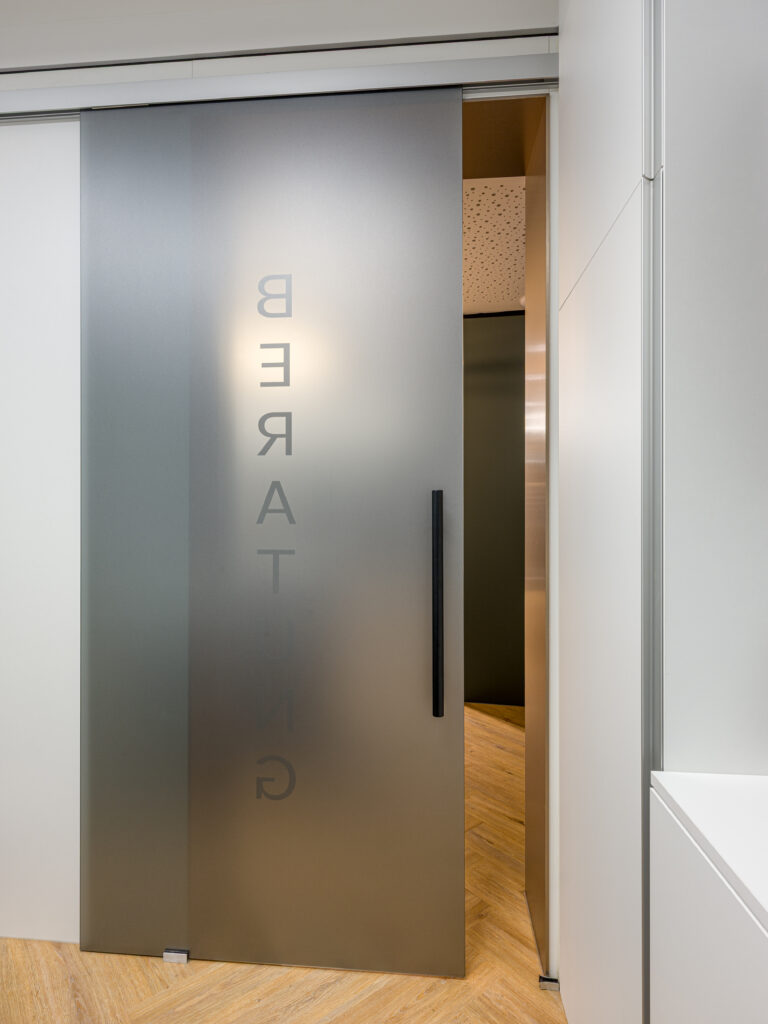 Durchgangsbereich mit Glaswand und Holzoptik – Innenarchitekturfotografie Rosenheim von Alexander Gerner