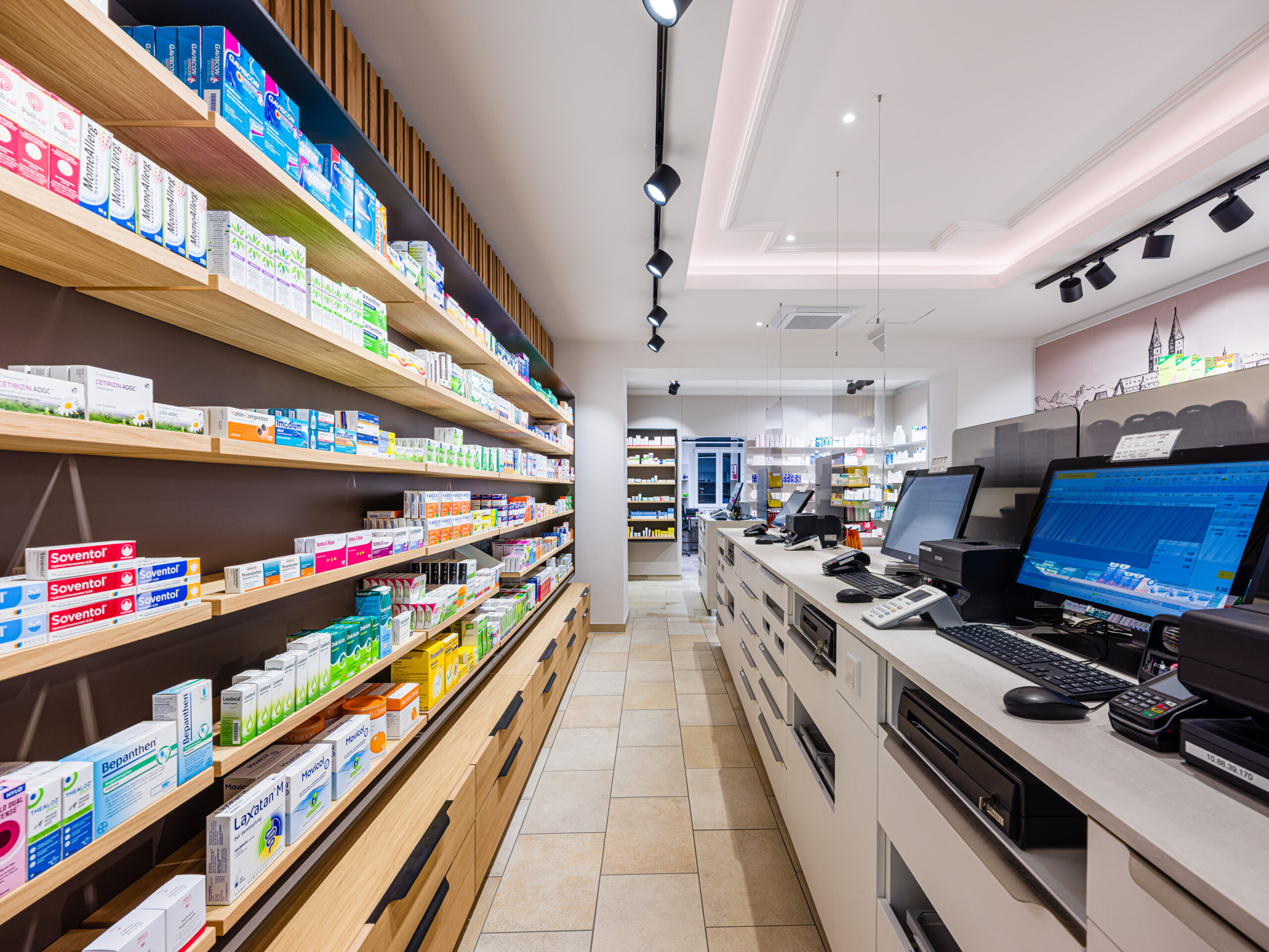 Lange Perspektive entlang der Produktregale mit Fokus auf Raumtiefe – professionelle Architekturfotografie Apotheke Freising