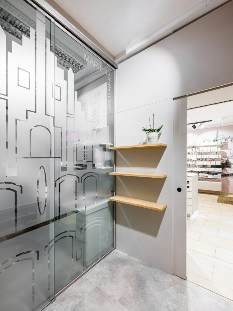 Glasabtrennung mit grafischem Muster – moderne Innenarchitektur im medizinischen Bereich