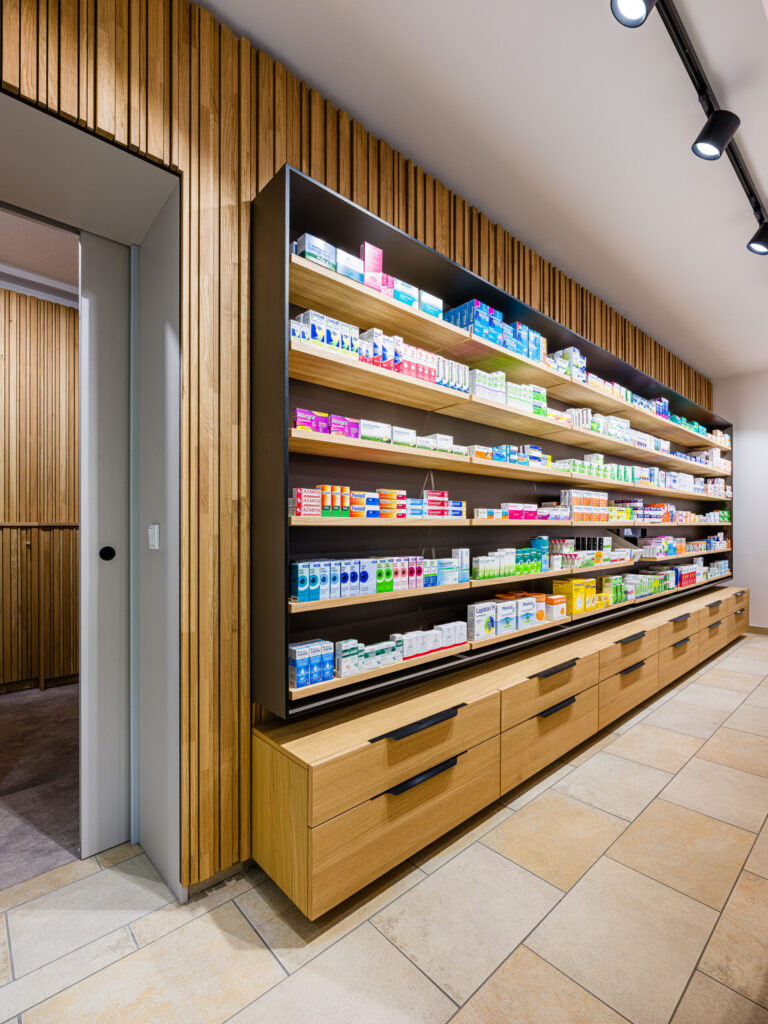 Regalwand mit integrierter Beleuchtung und Schubladenelementen – Apothekenumbau fotografiert vom Architekturfotograf