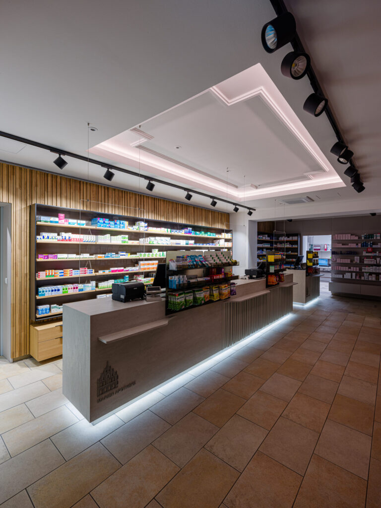 Verkaufsbereich mit indirekter Lichtführung und klarer Deckenstruktur – Interior Design Apotheke Freising
