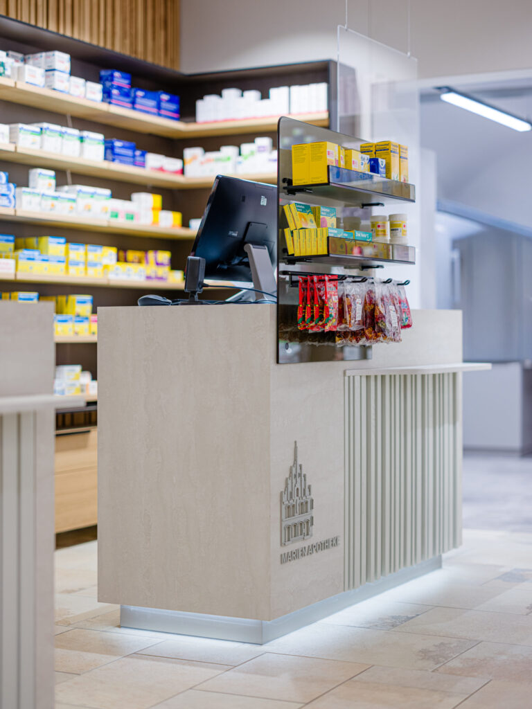Detail des Verkaufstresens mit Apothekenlogo – Architekturfotografie für Planquelle in Freising
