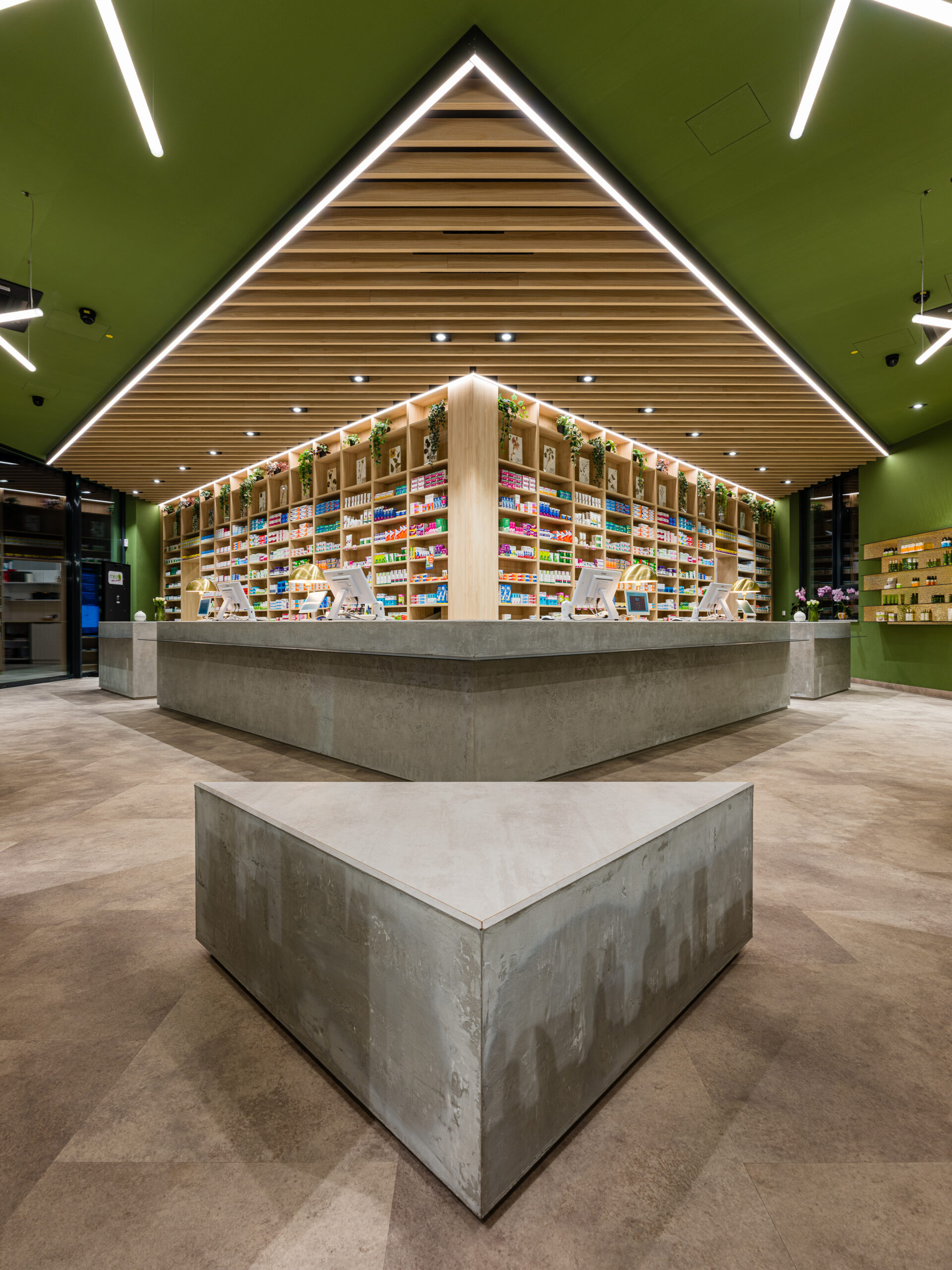 Zentraler Beratungstresen aus Sichtbeton, modernes Apotheken-Design in Bayern.