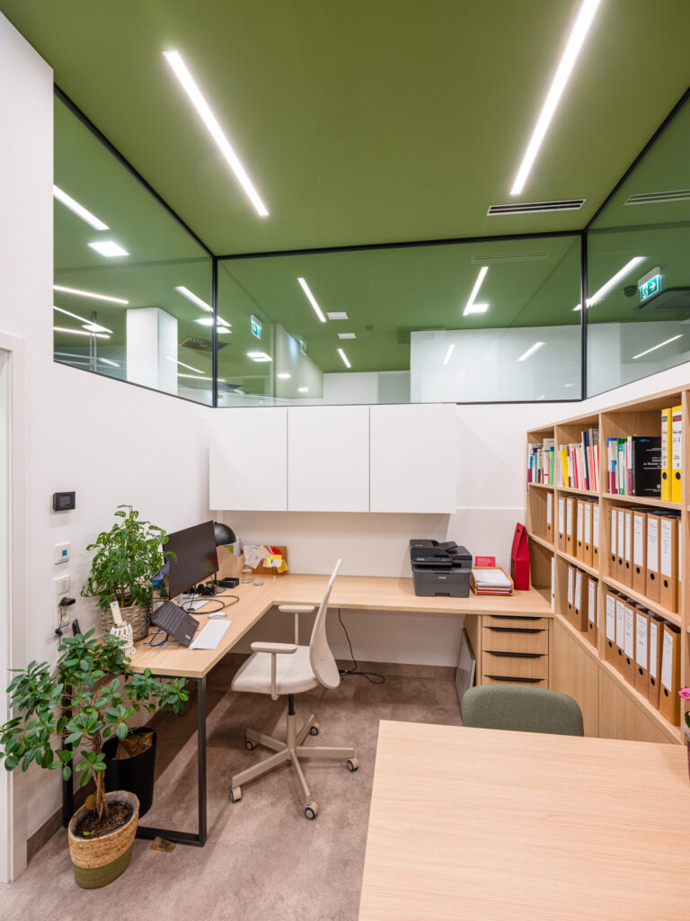 Heller Büroplatz mit grünen Akzenten, moderne Büro-Architekturfotografie.
