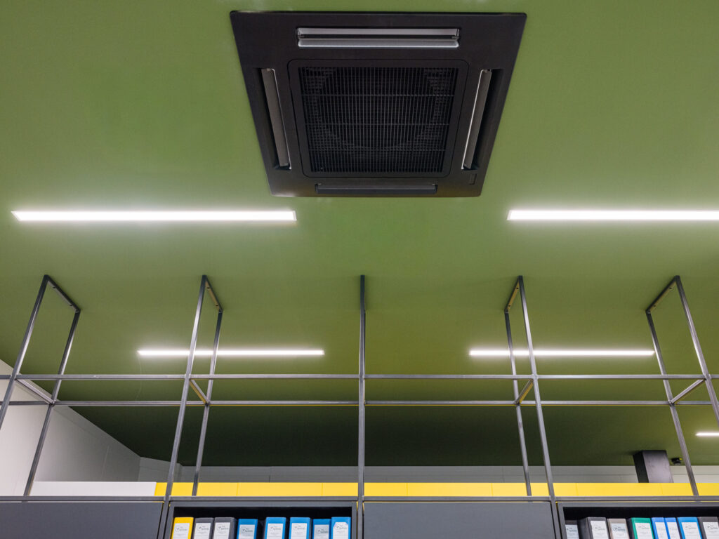 Detail der Lichtinstallation und Deckenkonstruktion in Grün und Gelb.