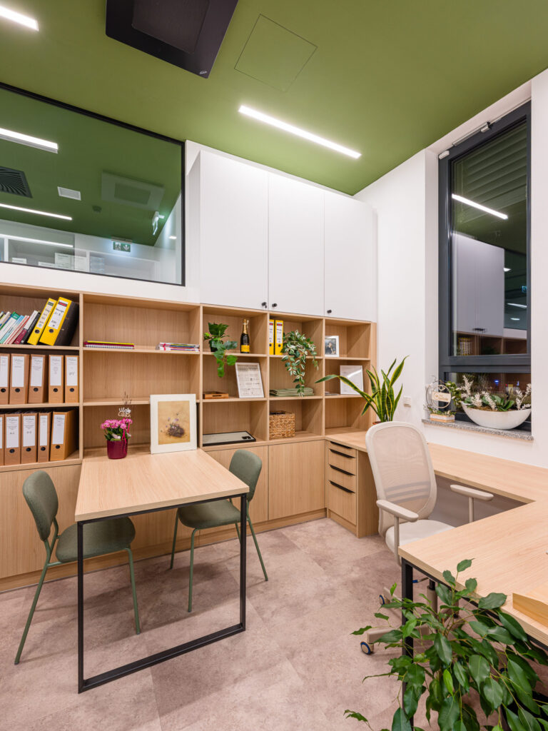 Heller Büroplatz mit grünen Akzenten, moderne Büro-Architekturfotografie.